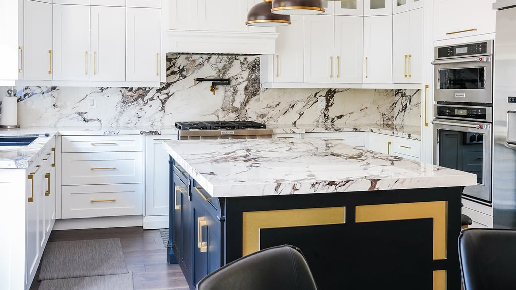 Kitchen renovation by Prime Kitchen and Bath, Mississauga: the Macchiato kitchen — white shaker cabinets, veined marble backsplash and a navy island